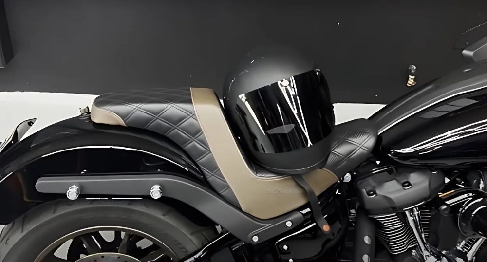 Matte black Biltwell Gringo helmet with a tinted visor resting on a motorcycle seat.