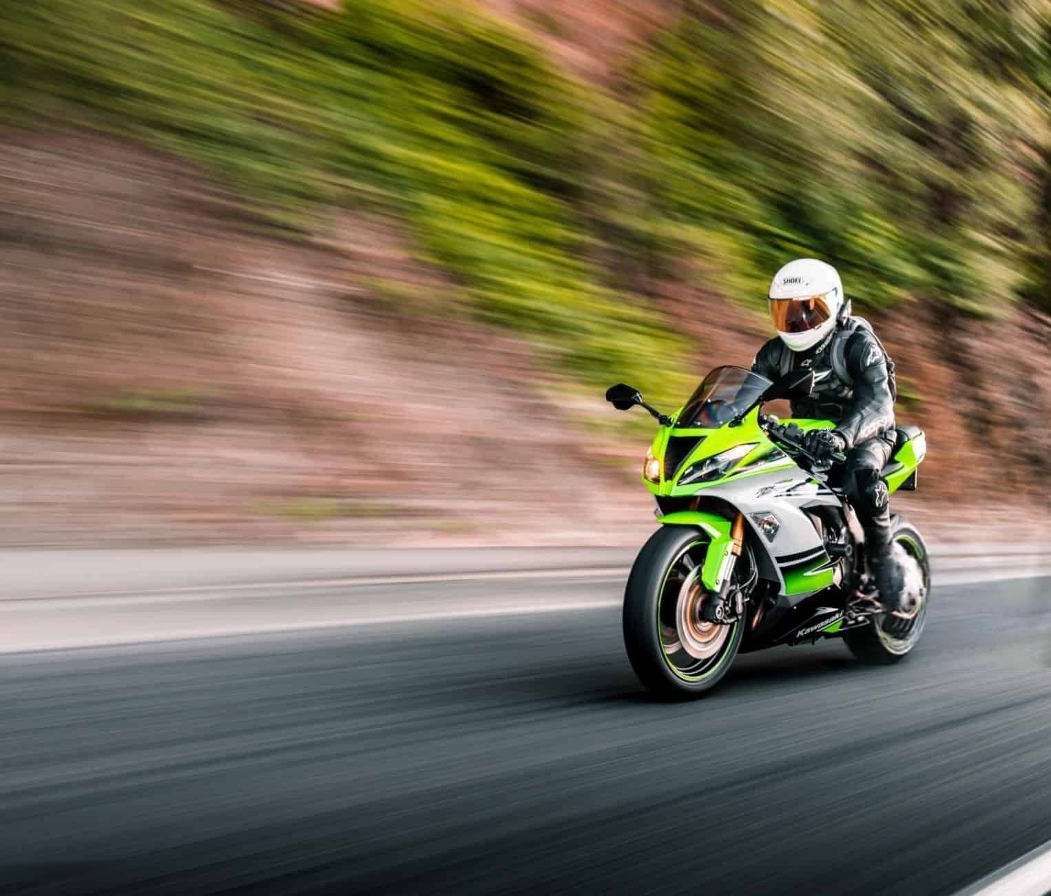 Motorcyclist in full gear riding at speed on a mountain road