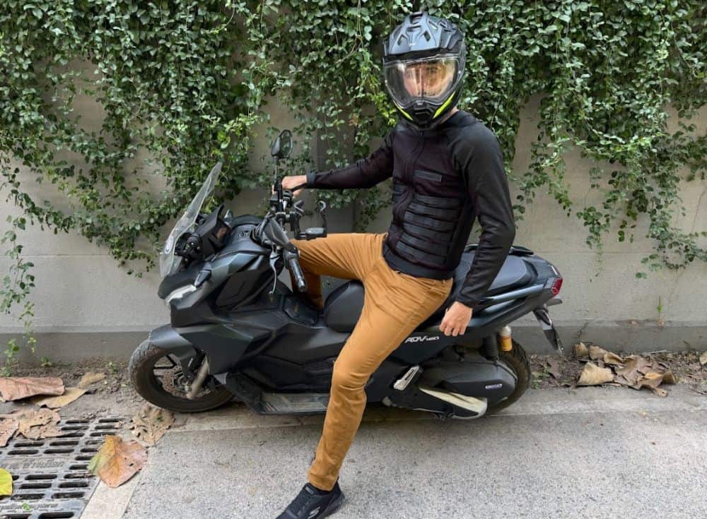 Urban motorcyclist on a scooter wearing Pando Moto armored underlayer and casual streetwear